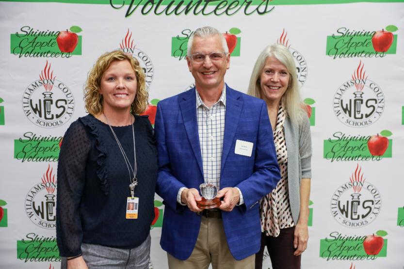 Two women and a man pose for a photo